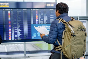 Young man at the airport checking for the flight schedule