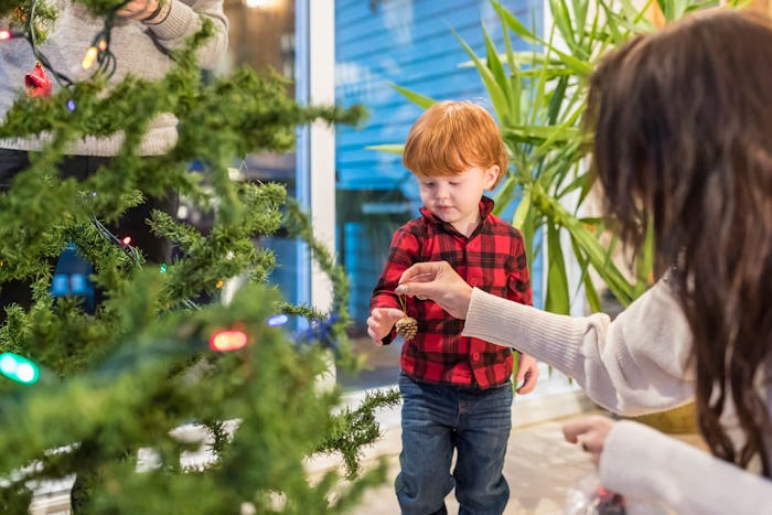 A young family of three is having fun while installing Christmas holiday decoration.