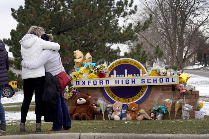 OXFORD, MICHIGAN - DECEMBER 01: People embrace as they visit a makeshift memorial outside of Oxford ...