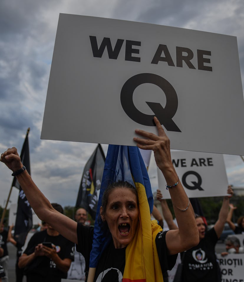 A woman shouts as she holds a placard reading "Q Army" (a reference to the Q-anon movement), during ...