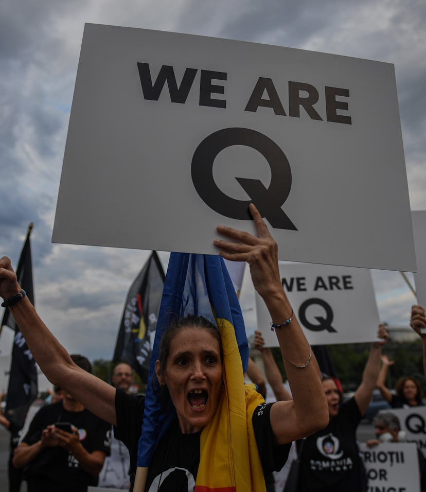 A woman shouts as she holds a placard reading "Q Army" (a reference to the Q-anon movement), during ...