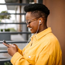 A person wearing wired headphones looks for their Apple Music Replay 2021, the iPhone-native version...