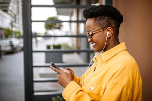 A person wearing wired headphones looks for their Apple Music Replay 2021, the iPhone-native version...