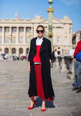 Olivia Palermo layered a red skirt, black coat, vest, white button shirt outside Dior on September 2...