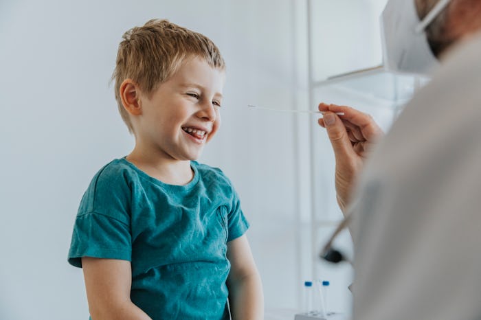 A little boy laughing before getting a Covid test up in his nose