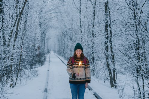A woman walks through a snowy path during the winter solstice. These 21 winter solstice quotes will ...