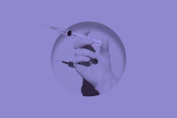 Doctor's hand holding syringe of Coronavirus vaccine placed inside round hole in pink paper.Digital ...