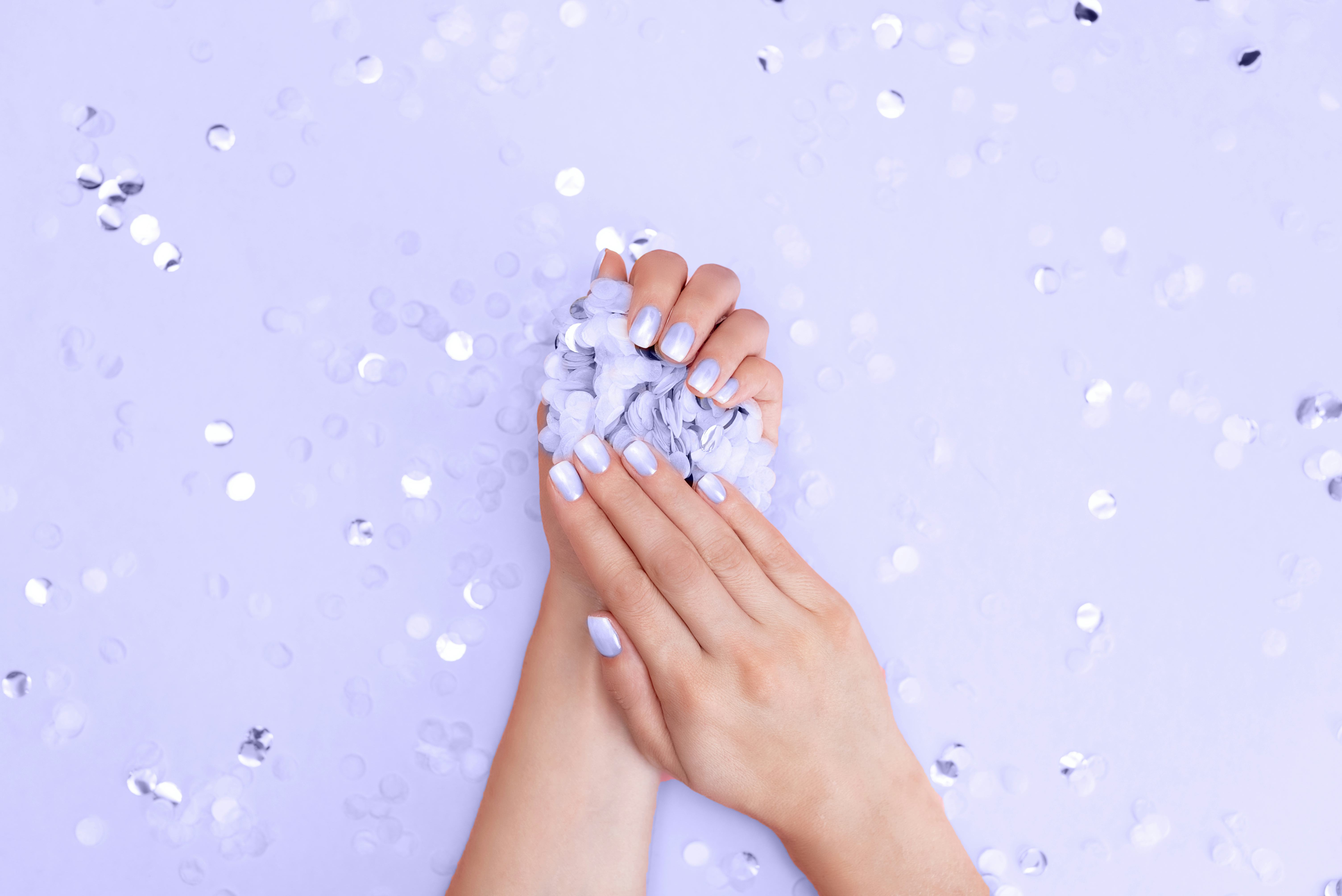 Hands with fresh pink lilac manicure.