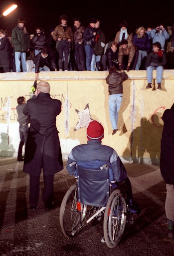 BRANDENBURG GATE, BERLIN, GERMANY - DECEMBER 31: A disabled man in a wheelchair is stalking...