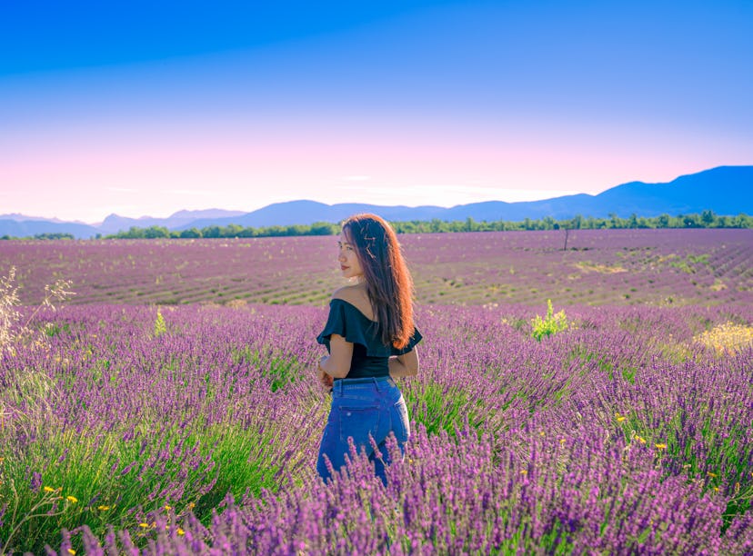 Woman enjoying lavender field as one of the very peri travel destinations inspired by Pantone's colo...