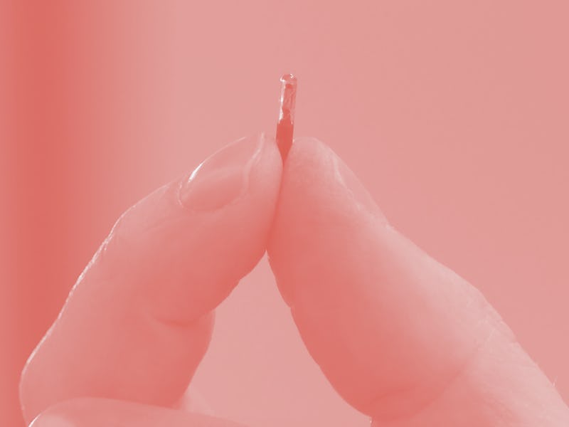 Hannes Sjoblad, director of DSruptive Subdermals, holds an implant between his fingers in Stockholm ...