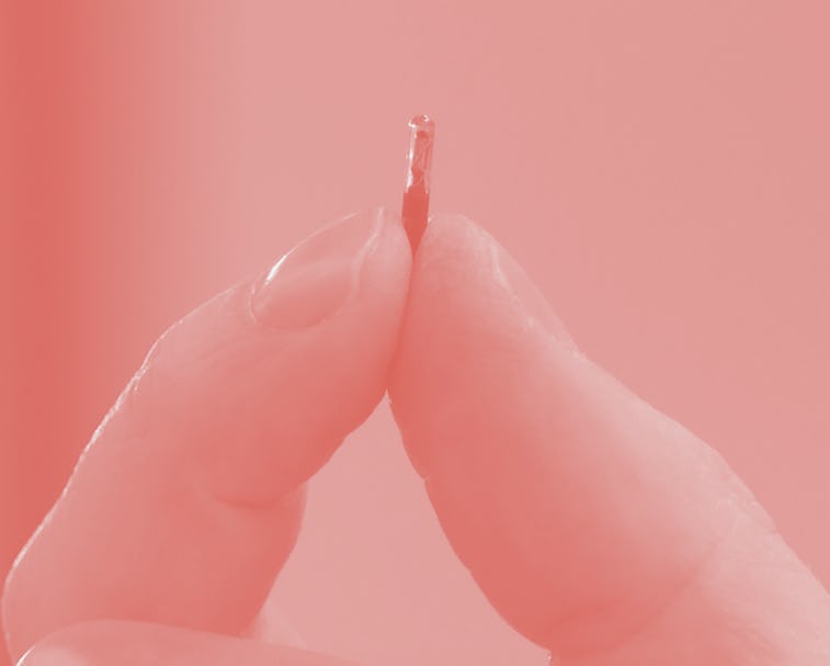 Hannes Sjoblad, director of DSruptive Subdermals, holds an implant between his fingers in Stockholm ...