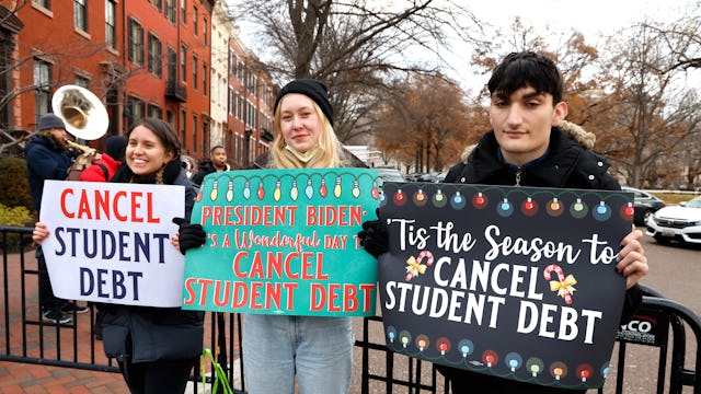 WASHINGTON, DC - DECEMBER 15: Activists hold festive signs calling on President Biden to cancel stud...