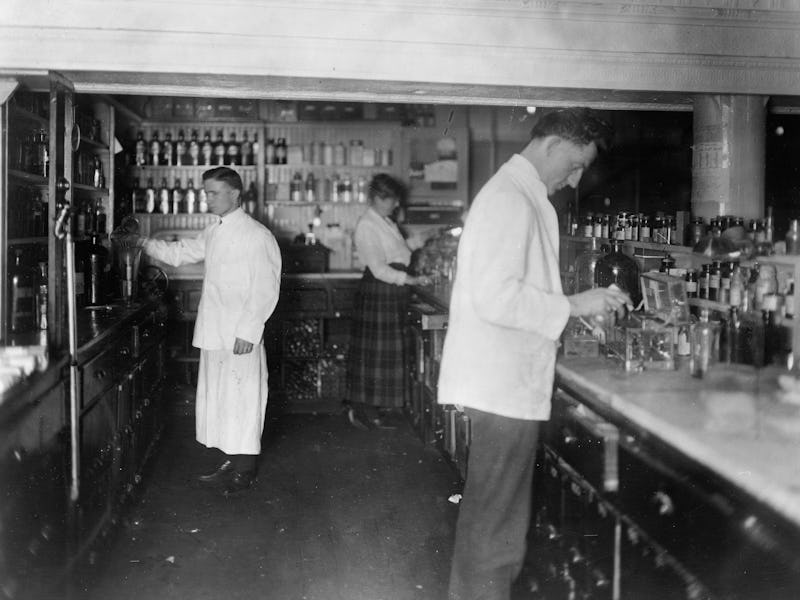 Pharmacists at People's Drug Store, 7th and E Streets, N.E., Washington, D.C., at counter preparing ...