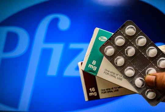 Medicine pills are seen with Pfizer logo in this illustration photo taken in Tehatta, West Bengal, ...