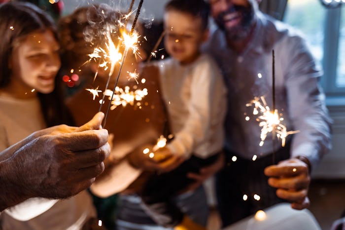 Family in living room during Christmas holidays, holding sprinklers