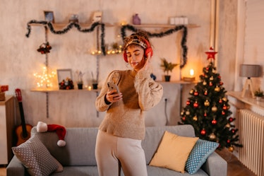 A woman listens to Christmas song lyrics, which she'll use for Instagram captions.