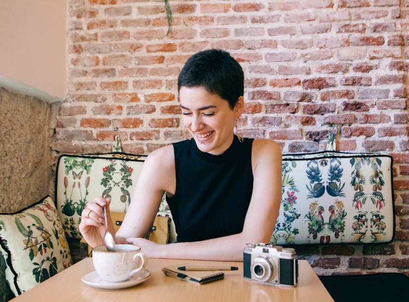 A happy woman drinking tea could use some gratitude affirmations to use with Instagram pictures. 