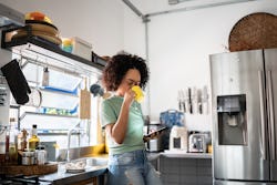 A woman drinks tea at home. Here's your daily horoscope for December 23, 2021.