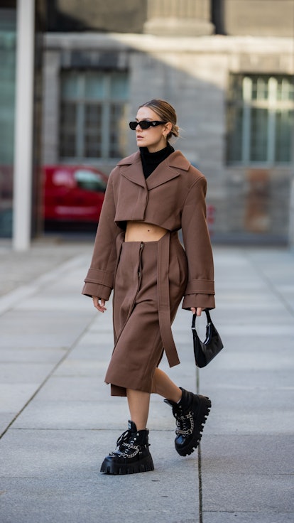 Alessa Winter is seen wearing brown Jacquemus cropped jacket and skirt with winter Miu Miu boots.