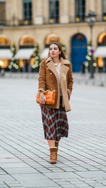 Maria Rosaria Rizzo wears a flannel skirt with fleece, winter boots, and a lined coat.