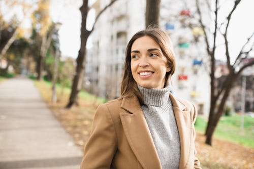 A woman in a gray turtleneck walks down a street. How Capricorn season 2021-2022 affects each zodiac...