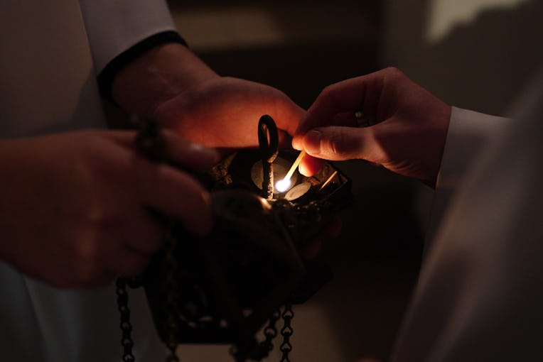 KALININGRAD, RUSSIA - DECEMBER 24, 2020: Roman Catholic believers light charcoal in an incense burne...
