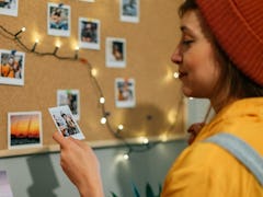 Woman at home pinning up vision board quotes as part of her vision board 2022.