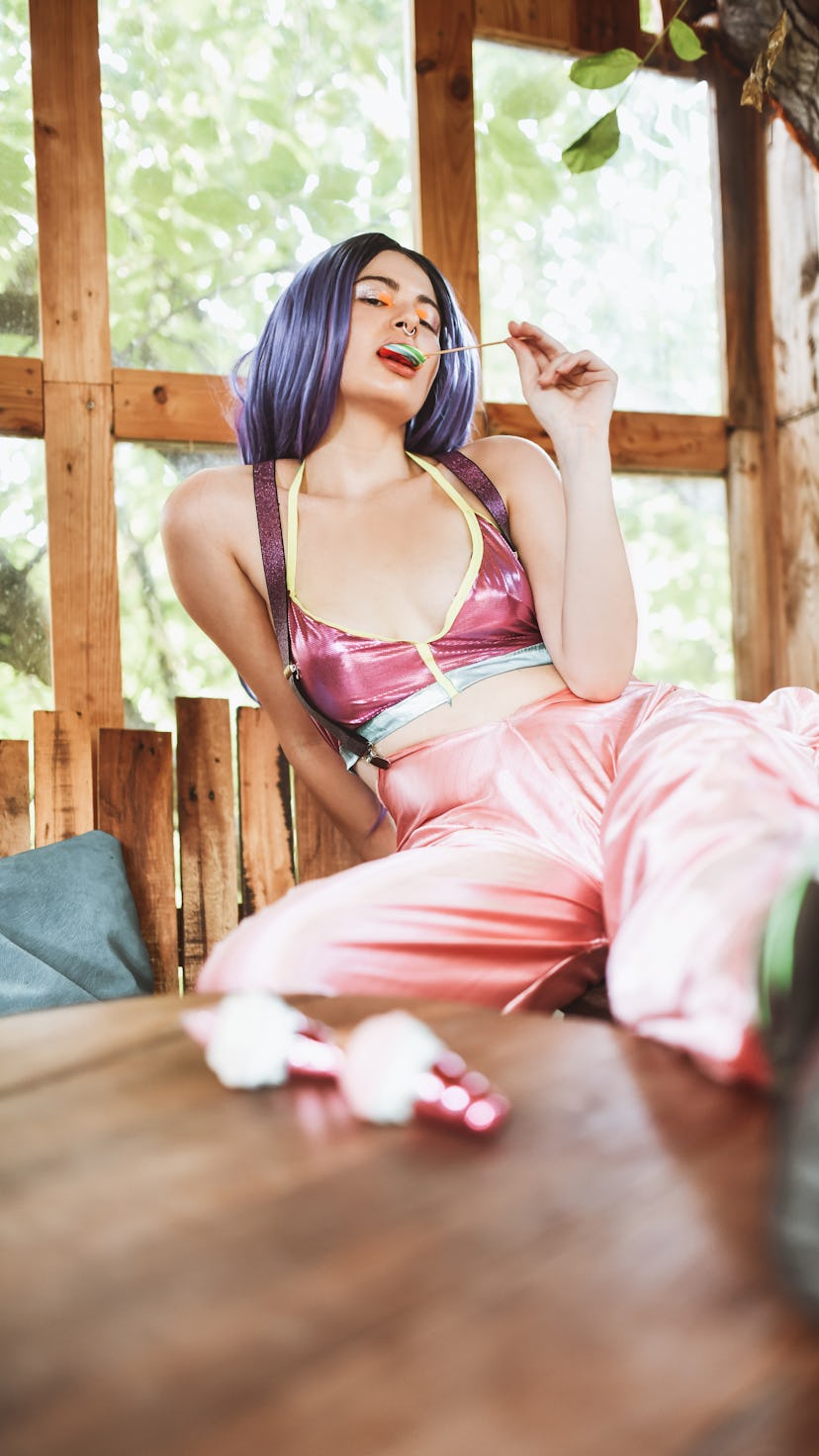 young woman eating lollipop as she thinks about her zodiac sign's favorite flavor