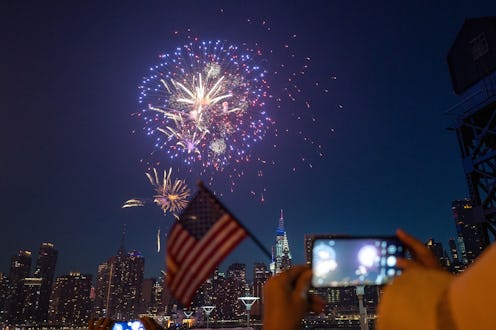 NEW YORK, NEW YORK - JULY 04: A woman waves an American flag during the 45th annual Macy’s 4th of Ju...