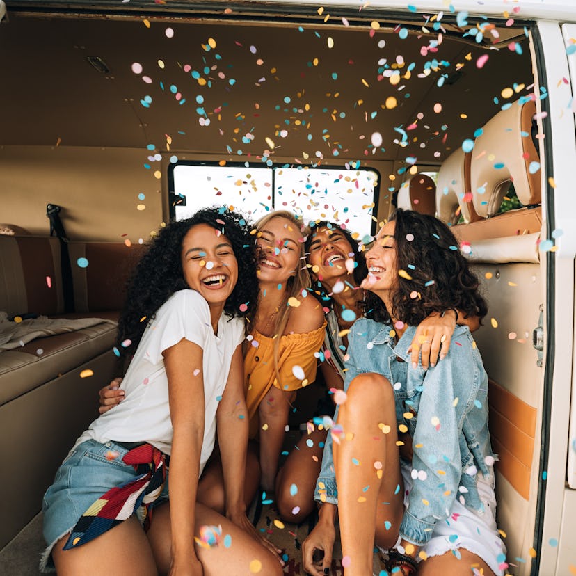 A group of young women celebrating each of their 2022 yearly friendship horoscopes for their zodiac ...