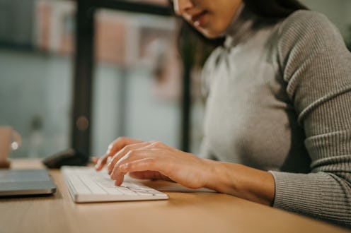 Young woman sitting in office and working on laptop