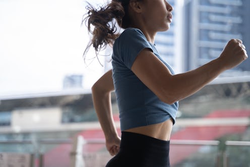 woman jogging on bridge for exercise with buildings background in the morning