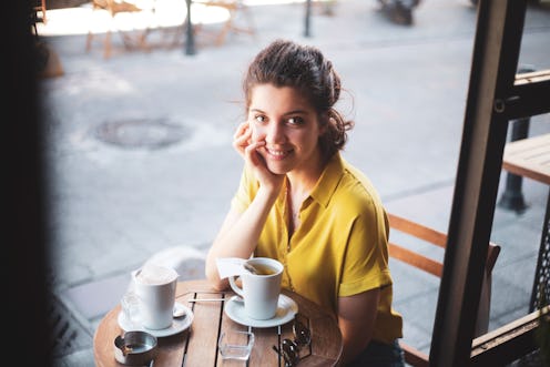 woman sitting at a cafe enjoying coffee