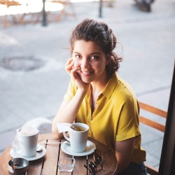 woman sitting at a cafe enjoying coffee