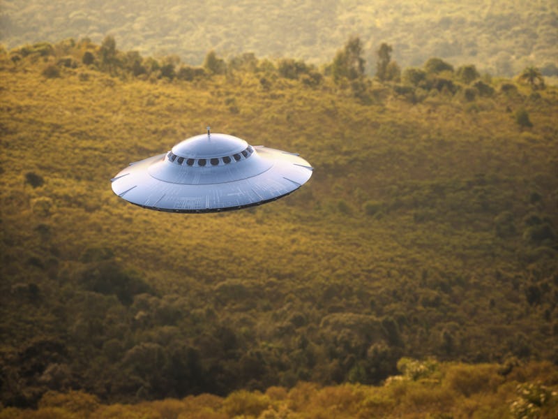 Illustration of a UFO gravitating over a forest and mountain ranges.