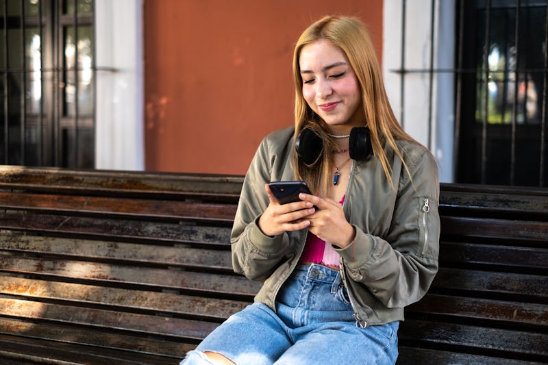 Teenager girl using the mobile phone outdoors