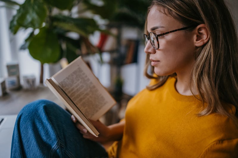 young woman reading a book at home.