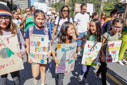 Kids hold placards while marching during the protest.