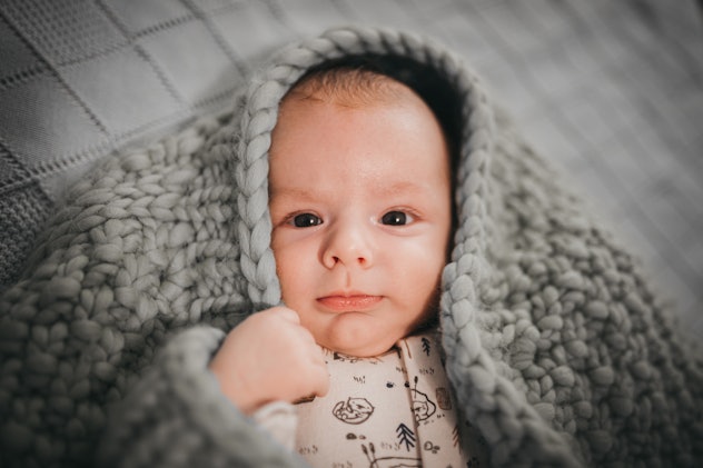Cute newborn baby boy wrapped in blanket in article about aquarius boy names