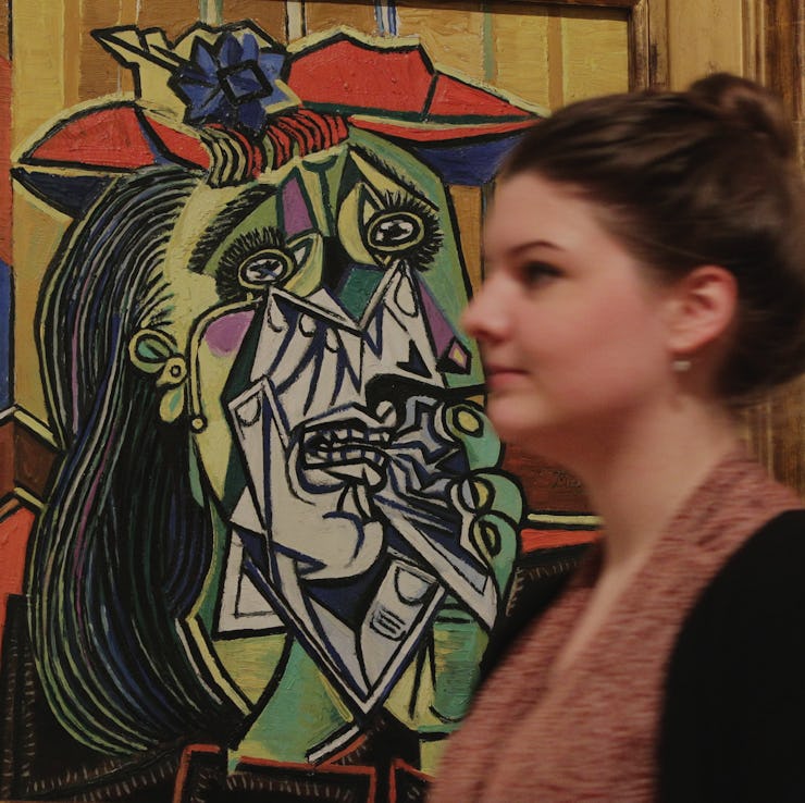 A member of the gallery staff walks past Weeping Woman (1937), by Pablo Picasso, on display during a...