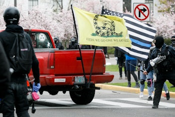 OREGON, USA - MARCH 28 : A Qanon supporter is chased by black bloc counter-protesters. More than a h...