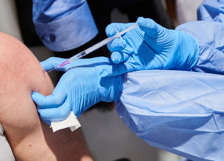 03 December 2021, Berlin: Vaccinator Mariam Heidar vaccinates a man at the vaccination centre in Kar...