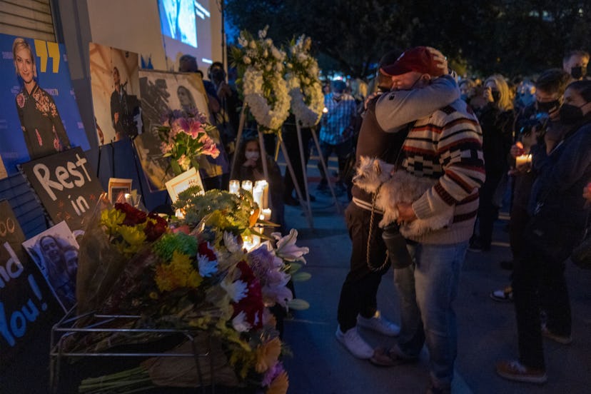 People hug near a memorial table during a candlelight vigil for cinematographer Halyna Hutchins, who...