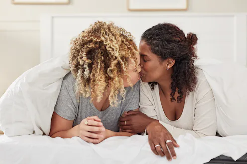 couple kissing in bed