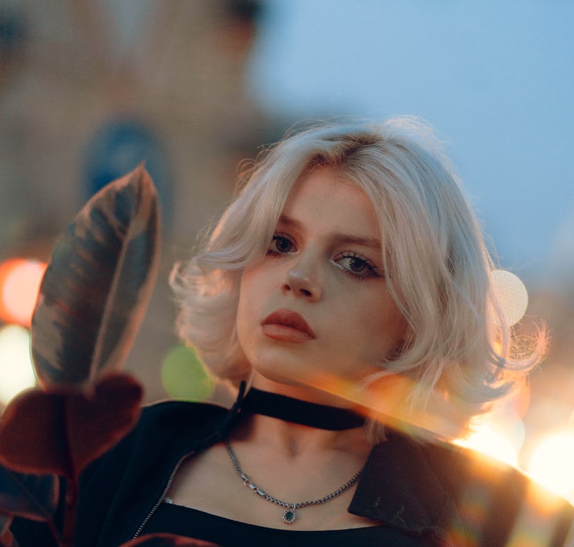 Young woman illuminated by street light, knowing that her zodiac sign experienced the most change du...