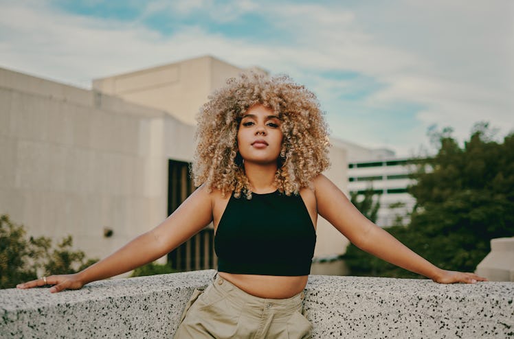 Young woman with blonde curly hair, thinking about how her zodiac sign will change in 2022.