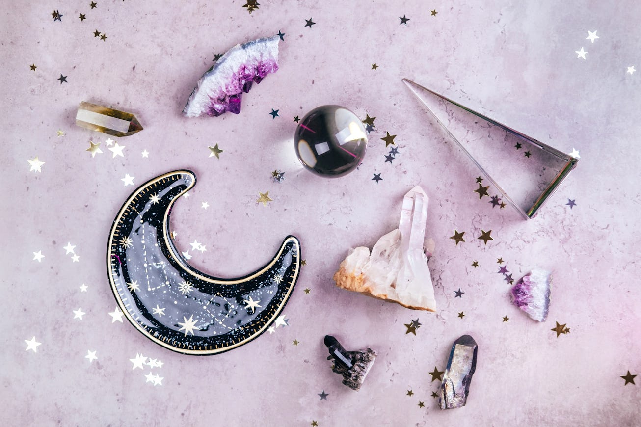 Magic set for rituals. Esoteric tools with crystal ball and many gemstone crystals on concrete gray ...