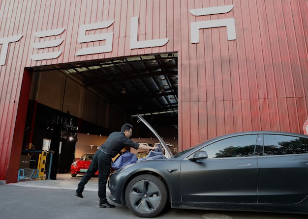 SHANGHAI, CHINA - AUGUST 23: A car owner places commodities for sale in the trunk of a Tesla vehicle...
