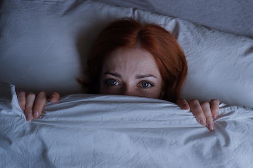 Woman peeking out of her blanket